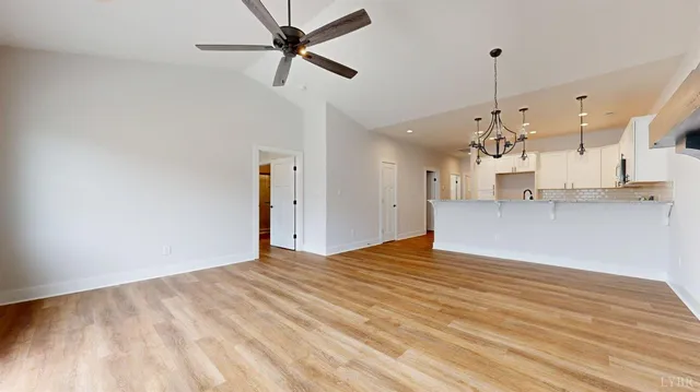 a view of a kitchen with wooden floor and a ceiling fan