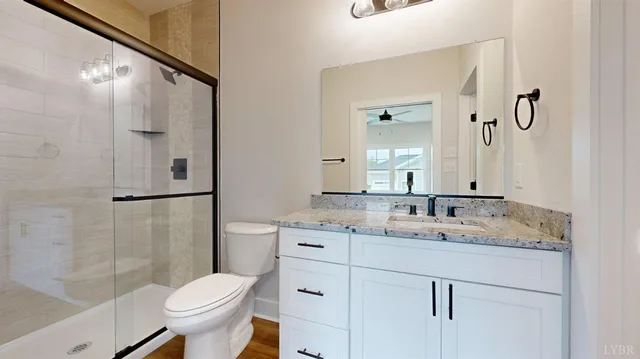 a bathroom with a granite countertop sink toilet and shower