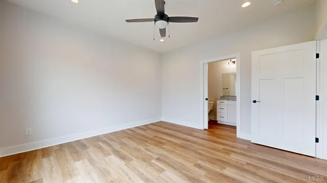 a view of empty room with wooden floor and ceiling fan