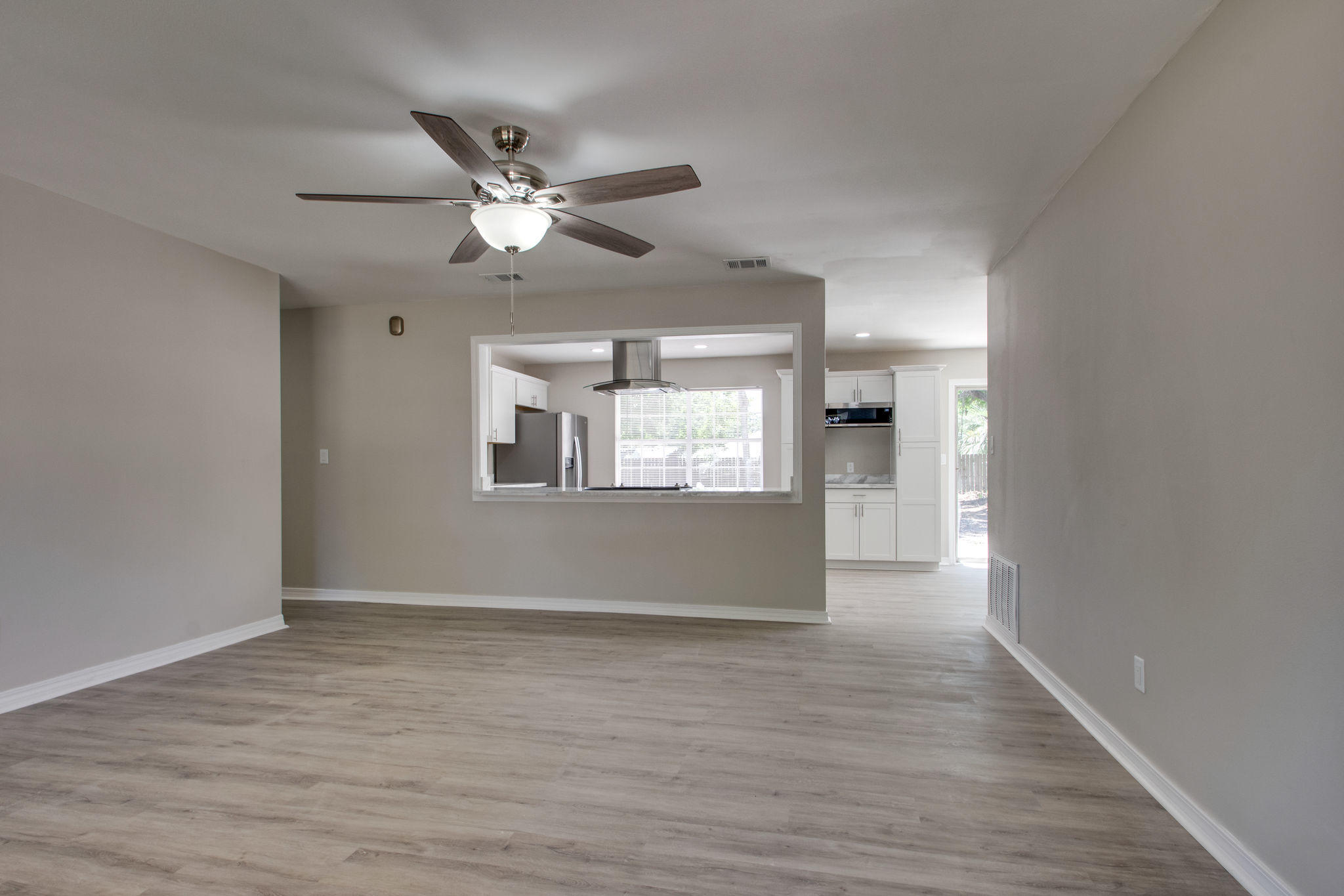 409 Main Street Destin, FL 32541 - Photo 7 of 19 a view of an empty room with wooden floor and a ceiling fan
