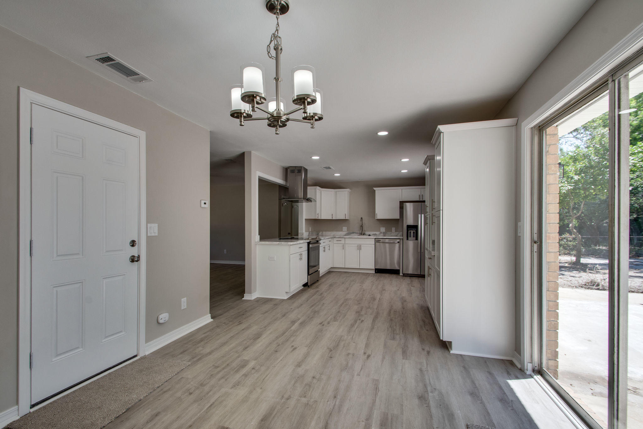 409 Main Street Destin, FL 32541 - Photo 10 of 19 a view of a hallway with wooden floor and a kitchen