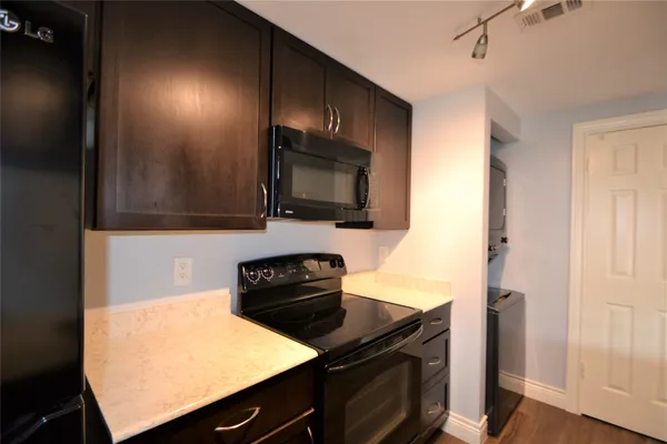a kitchen with stainless steel appliances granite countertop a stove a sink and a microwave