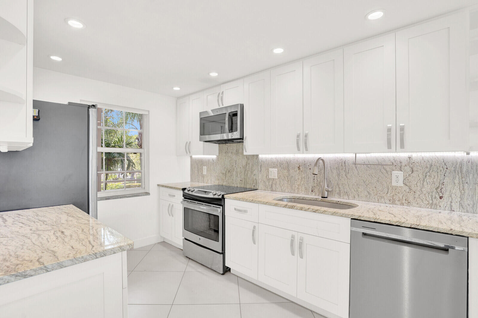 804 Cypress Boulevard, Unit 301 Pompano Beach, FL 33069 - Photo 11 of 34 a kitchen with granite countertop white cabinets and white appliances