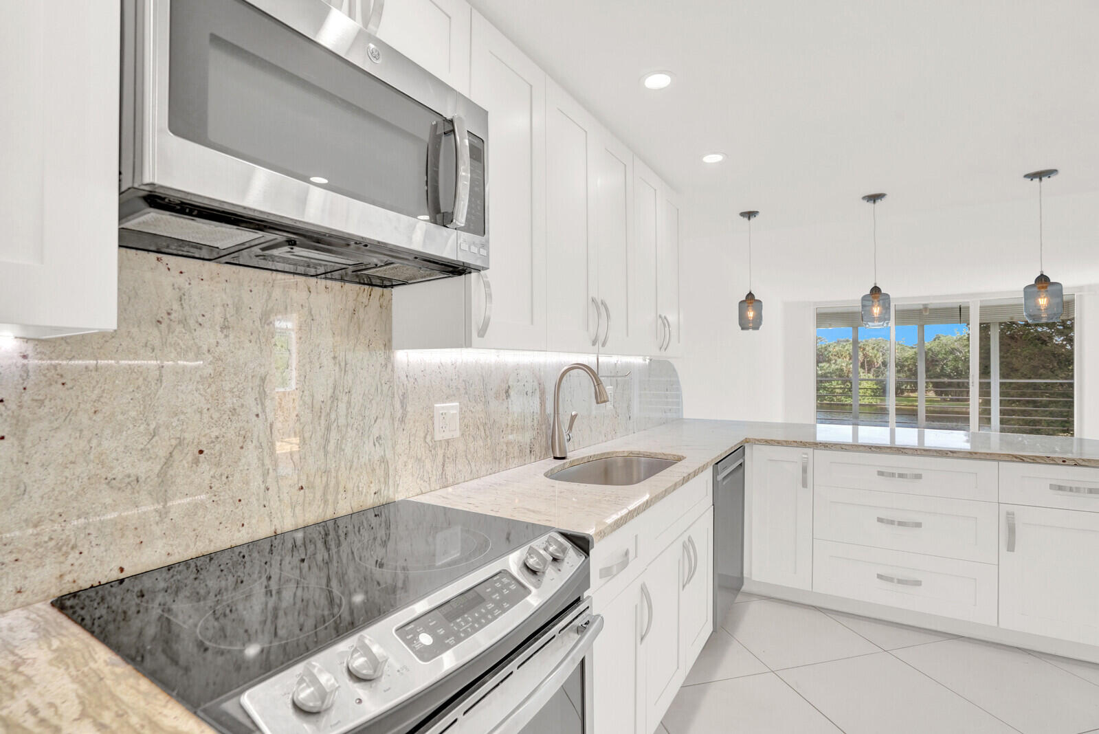 804 Cypress Boulevard, Unit 301 Pompano Beach, FL 33069 - Photo 12 of 34 a kitchen with a sink stove and cabinets