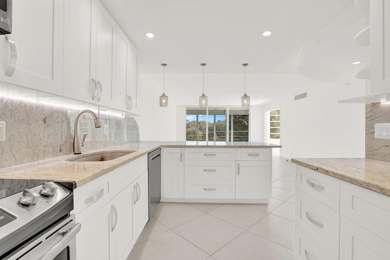 804 Cypress Boulevard, Unit 301 Pompano Beach, FL 33069 - Photo 13 of 34 a kitchen with granite countertop white cabinets and white appliances