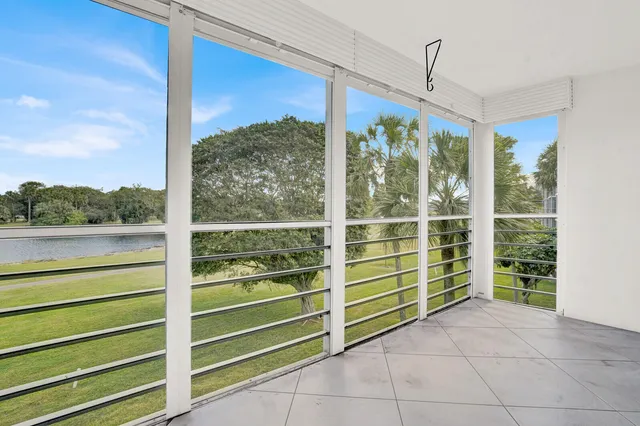 a view of a porch with a floor to ceiling window and a yard