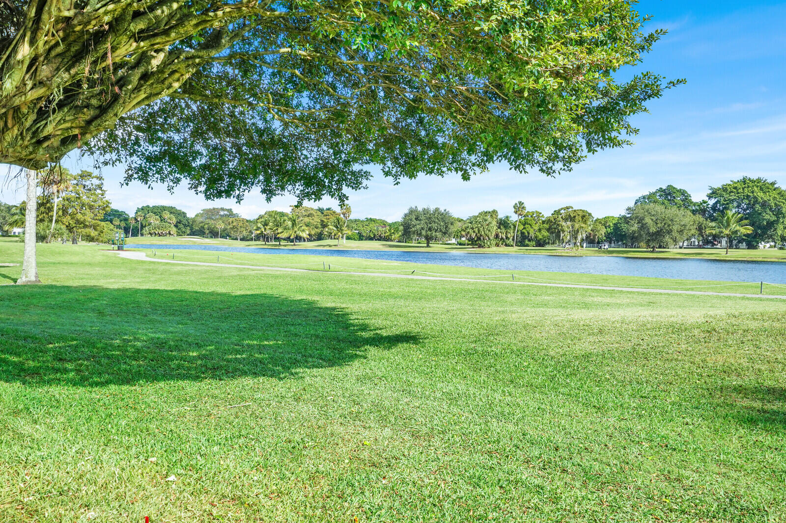 804 Cypress Boulevard, Unit 301 Pompano Beach, FL 33069 - Photo 31 of 34 a yard with lots of green space and trees in the back