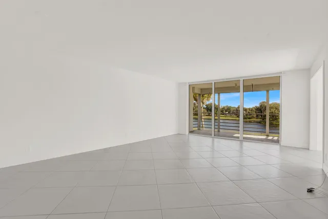 an empty room with chandelier fan and table