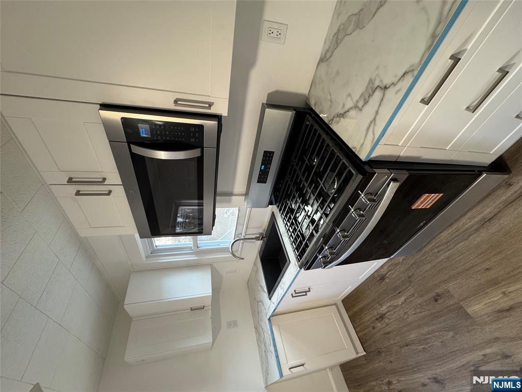 57 Old Hook Road, Unit 2 Westwood, NJ 07675 - Photo 3 of 13 a kitchen with a stove and a microwave