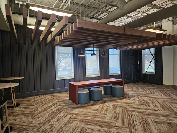 a kitchen with stainless steel appliances granite countertop a stove a refrigerator a dining table and chairs with wooden floor