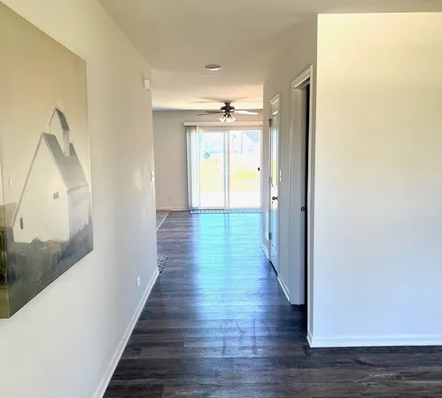 a view of a hallway with wooden floor