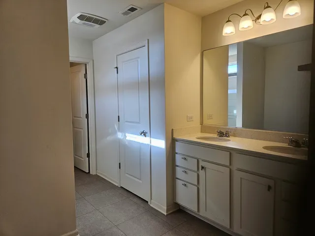 a bathroom with a double vanity sink and a mirror
