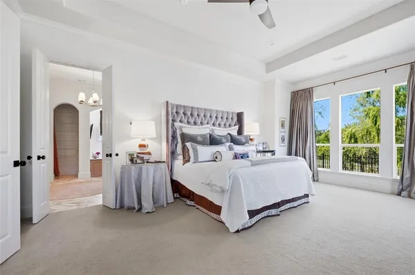 a spacious bedroom with a bed and a chandelier