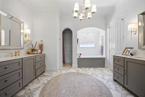 a spacious bathroom with a tub sink and mirror