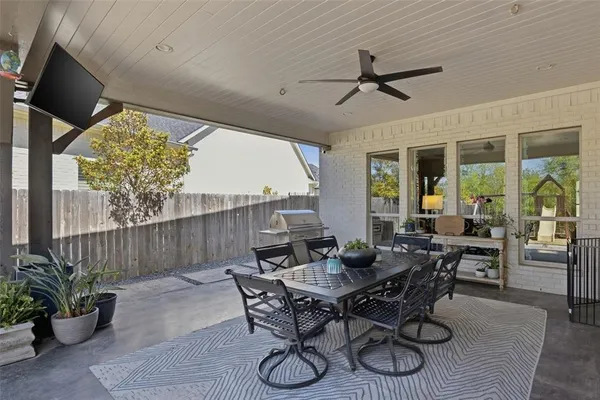 a view of a patio with table and chairs potted plants with wooden floor and fence
