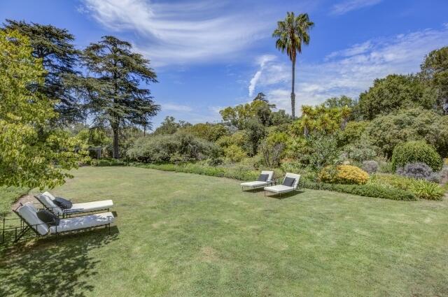 780 Mission Canyon Road Santa Barbara, CA 93105 - Photo 75 of 97 a view of a backyard with table and chairs plants and large trees