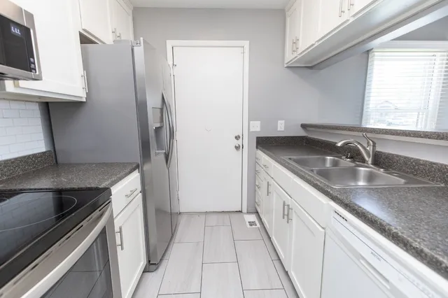 a kitchen with a sink stove and refrigerator