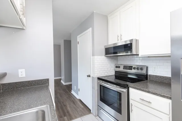 a kitchen with stainless steel appliances a stove microwave and sink