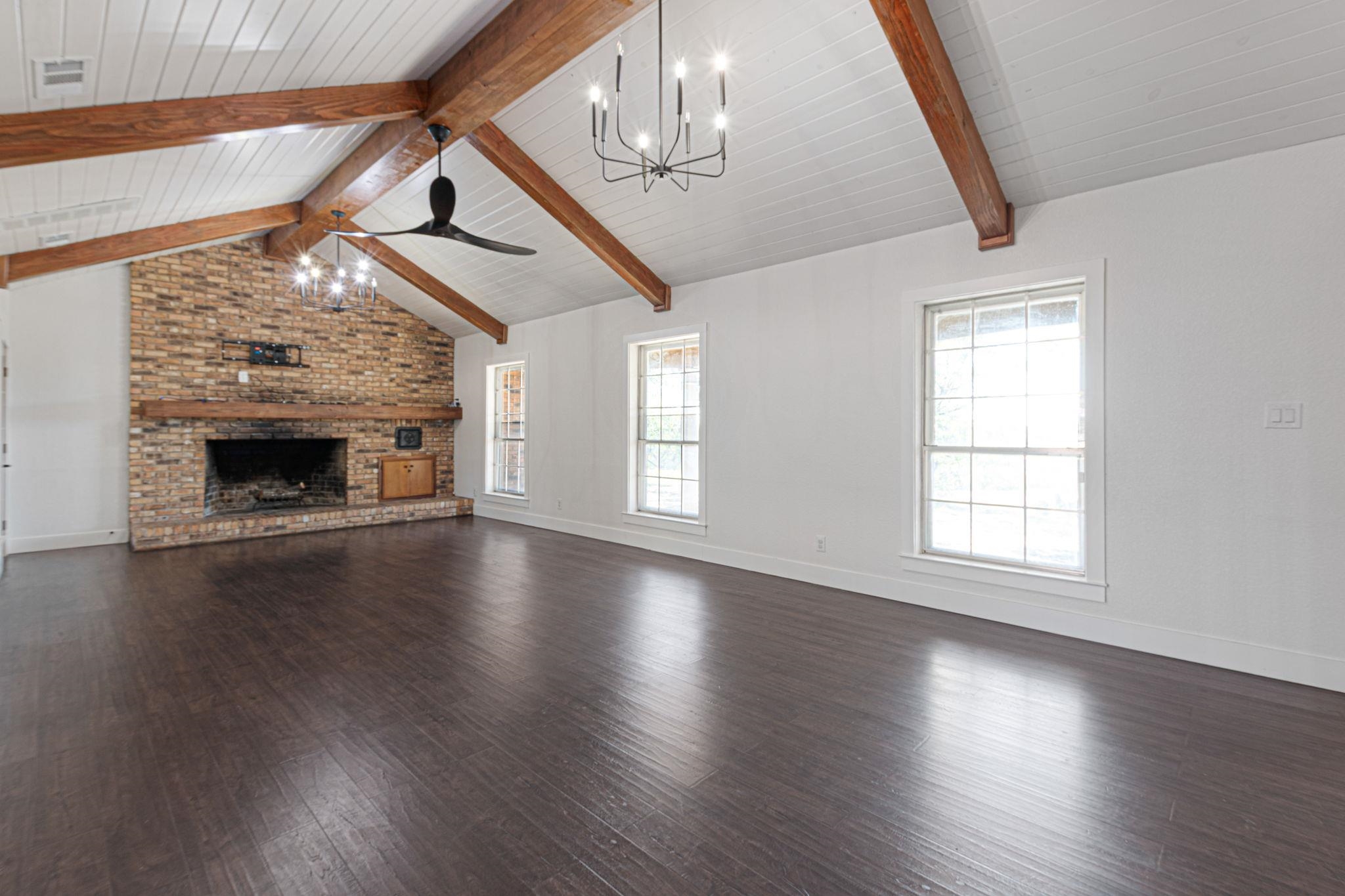 1307 Nix Road Lampasas, TX 76550 - Photo 4 of 30 an empty room with wooden floor fireplace and windows