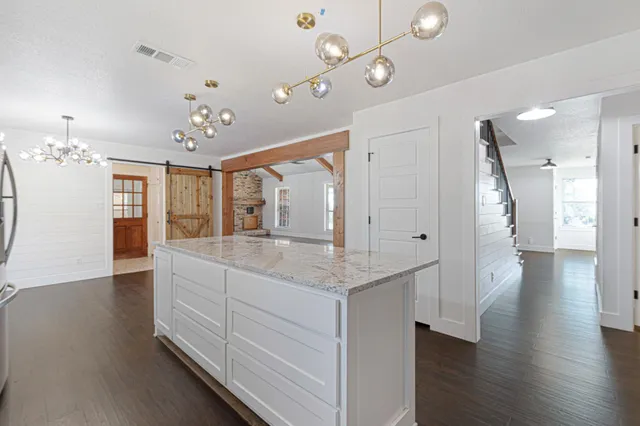 a spacious bathroom with a granite countertop sink a mirror and shower
