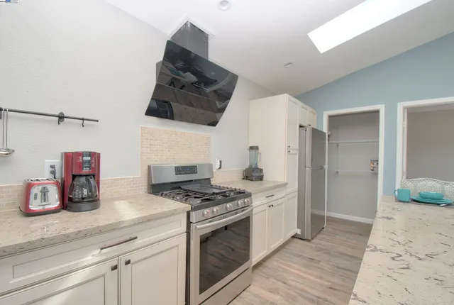 a kitchen with granite countertop a sink stove and refrigerator