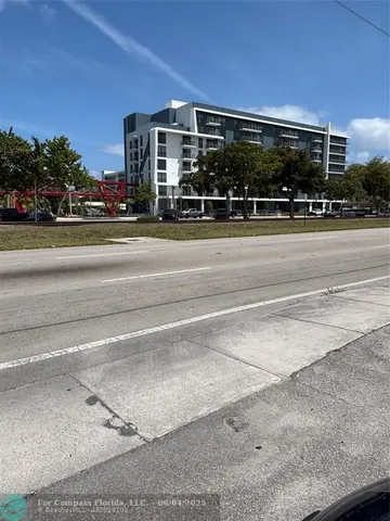 a view of street with a cars parked in front of it