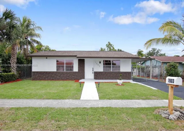 a front view of a house with a yard and palm tree