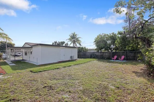 a kitchen with stainless steel appliances granite countertop a refrigerator a sink a stove and a refrigerator with wooden floor