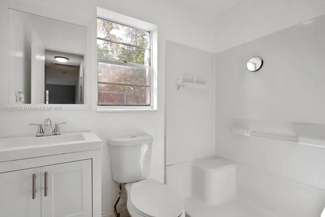 a view of a backyard with table and chairs with wooden fence