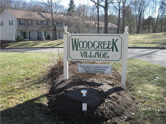 a view of a street sign under a large tree