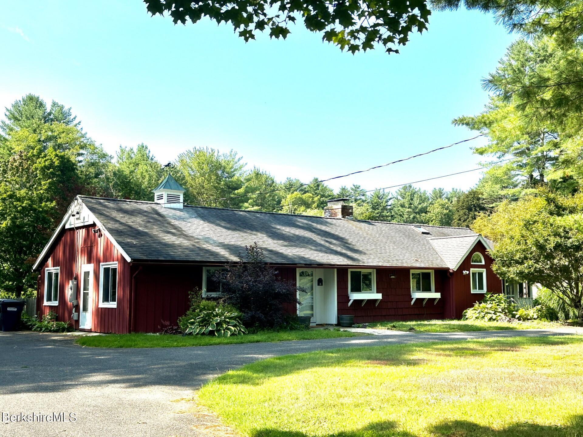a front view of a house with a garden and trees