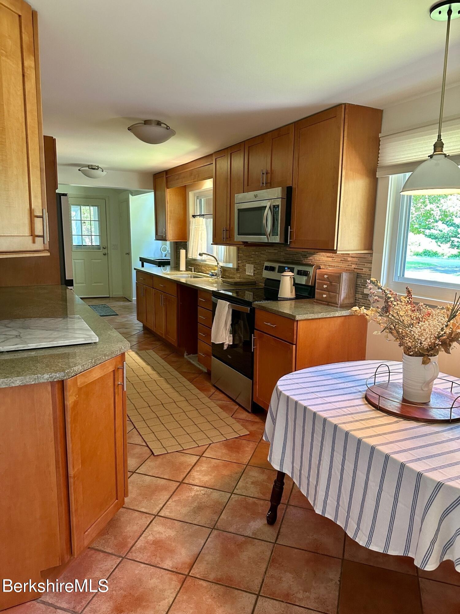 5 Cherry Hill Road Stockbridge, MA 01262 - Photo 4 of 39 a kitchen with stainless steel appliances kitchen island granite countertop a sink dishwasher stove top oven and cabinets
