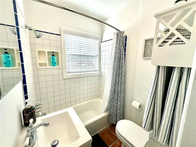 a bathroom with a sink a toilet a mirror and shower