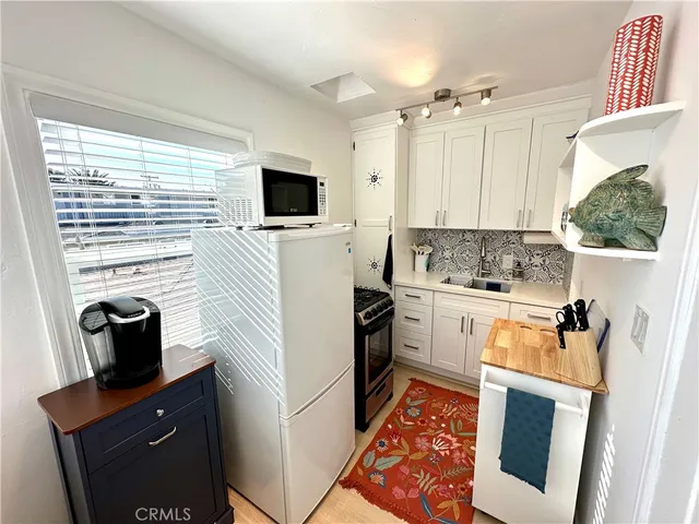 a kitchen with a refrigerator a stove top oven a sink and dishwasher