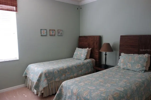 a bedroom with two beds and painting on the wall