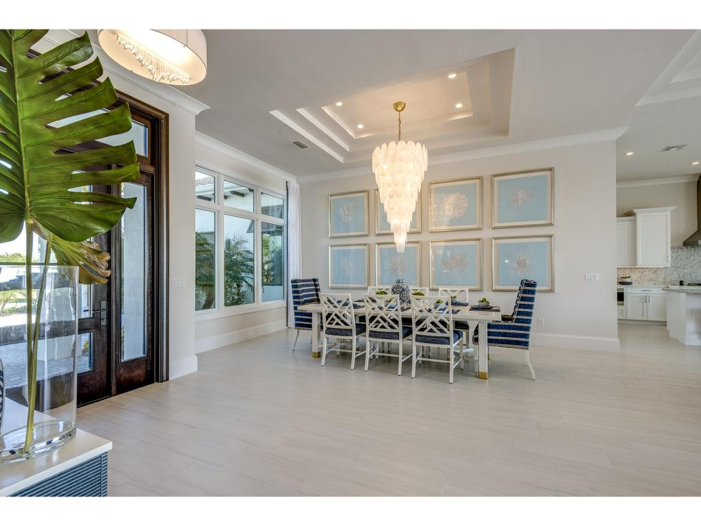 9828 Montiano Place Naples, FL 34113 - Photo 18 of 18 a view of a dining room with furniture and chandelier