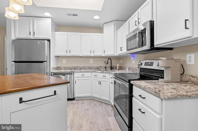 a kitchen with granite countertop a sink stove and refrigerator
