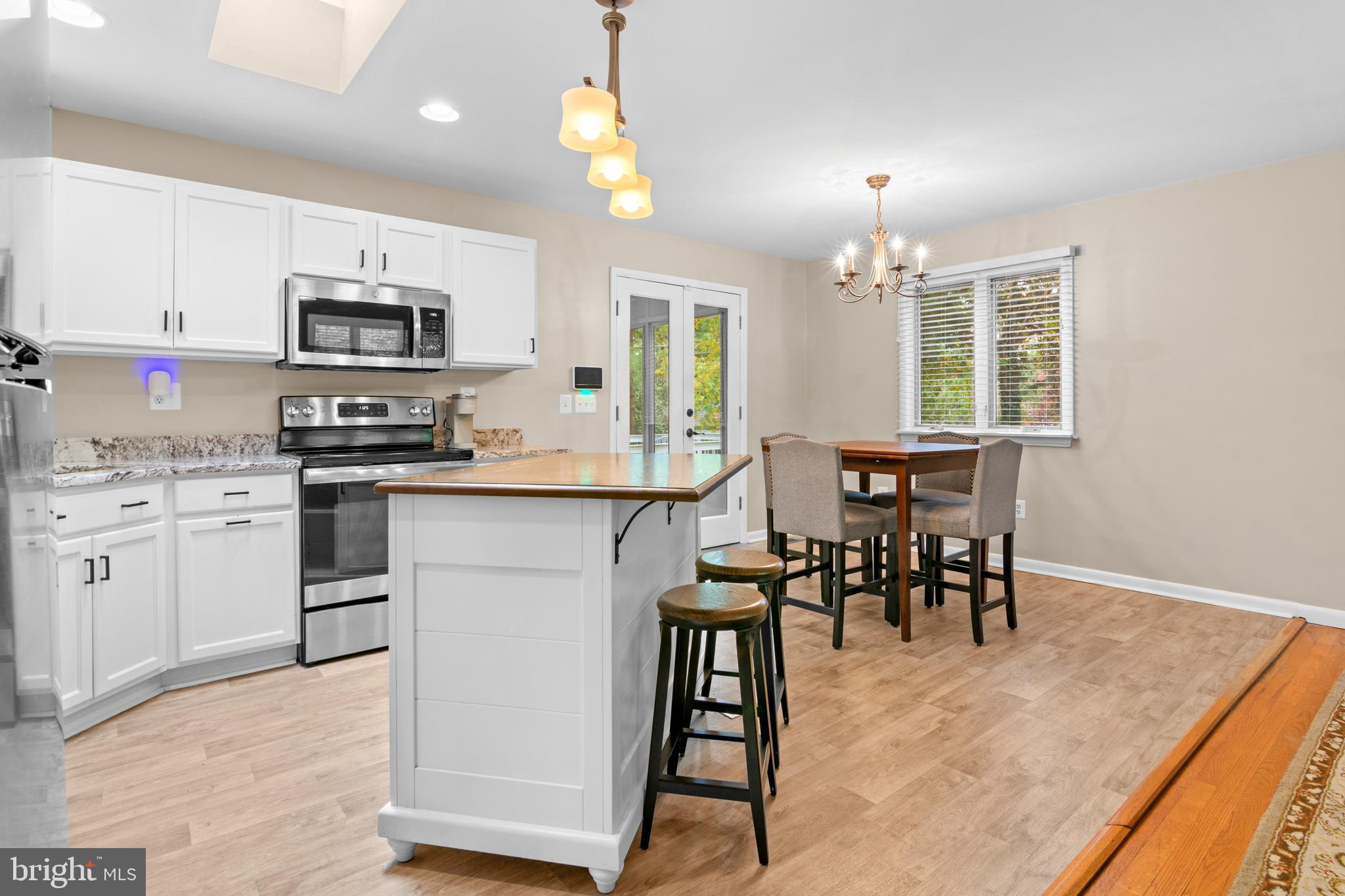 2709 Parkview Drive Riva, MD 21140 - Photo 14 of 53 a kitchen with stainless steel appliances granite countertop a stove top oven a sink a dining table and chairs with wooden floor