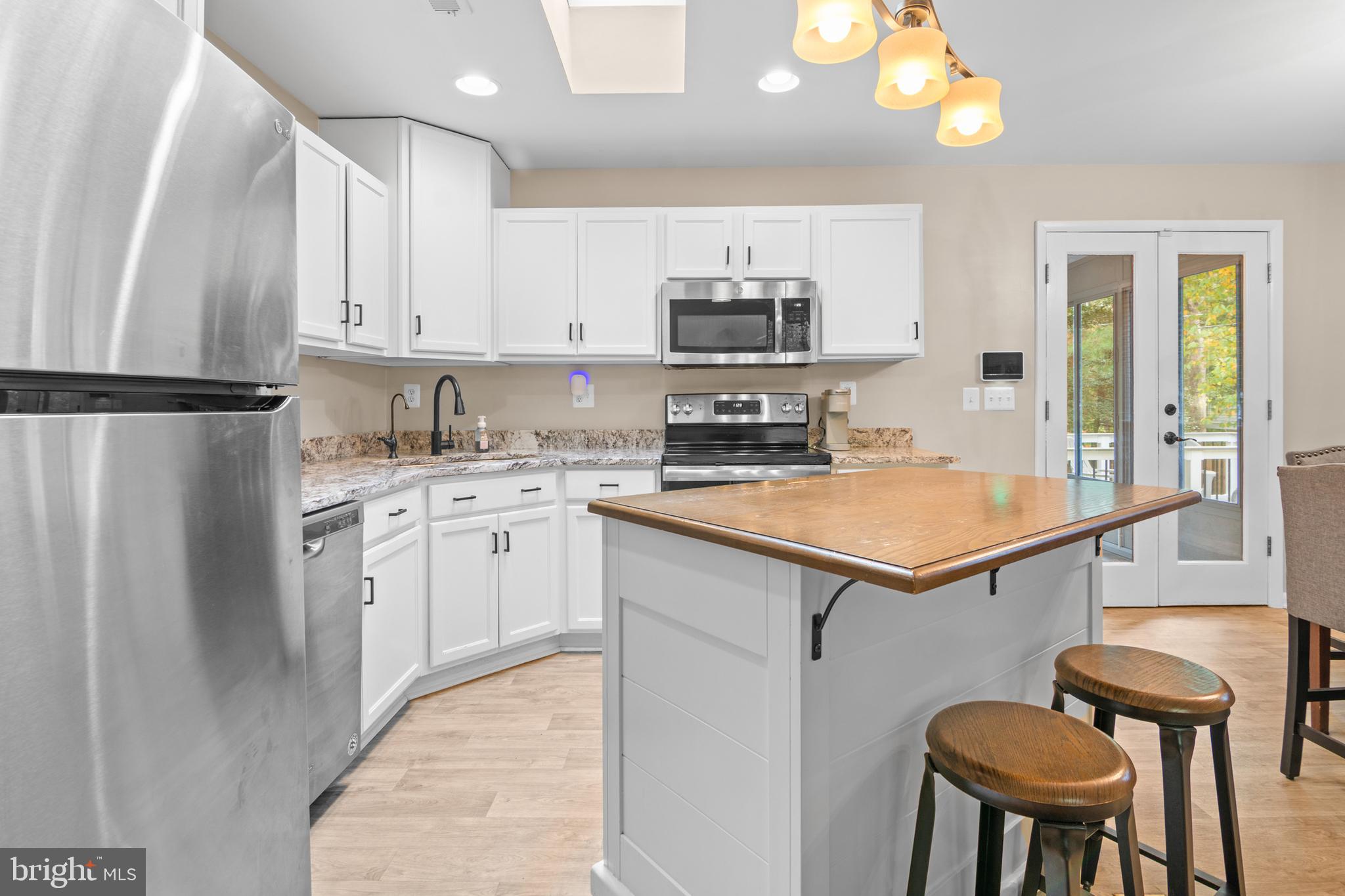 2709 Parkview Drive Riva, MD 21140 - Photo 15 of 53 a kitchen with stainless steel appliances a refrigerator a stove a sink dishwasher and white cabinets with wooden floor