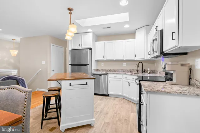 a kitchen with stainless steel appliances granite countertop a stove refrigerator sink and cabinets