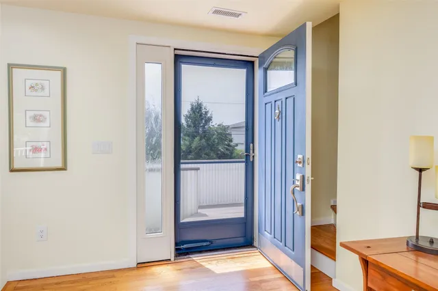 a view of a hallway with wooden floor and cabinet