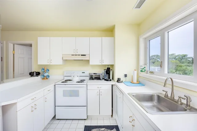 a kitchen with a sink stove top oven and cabinets