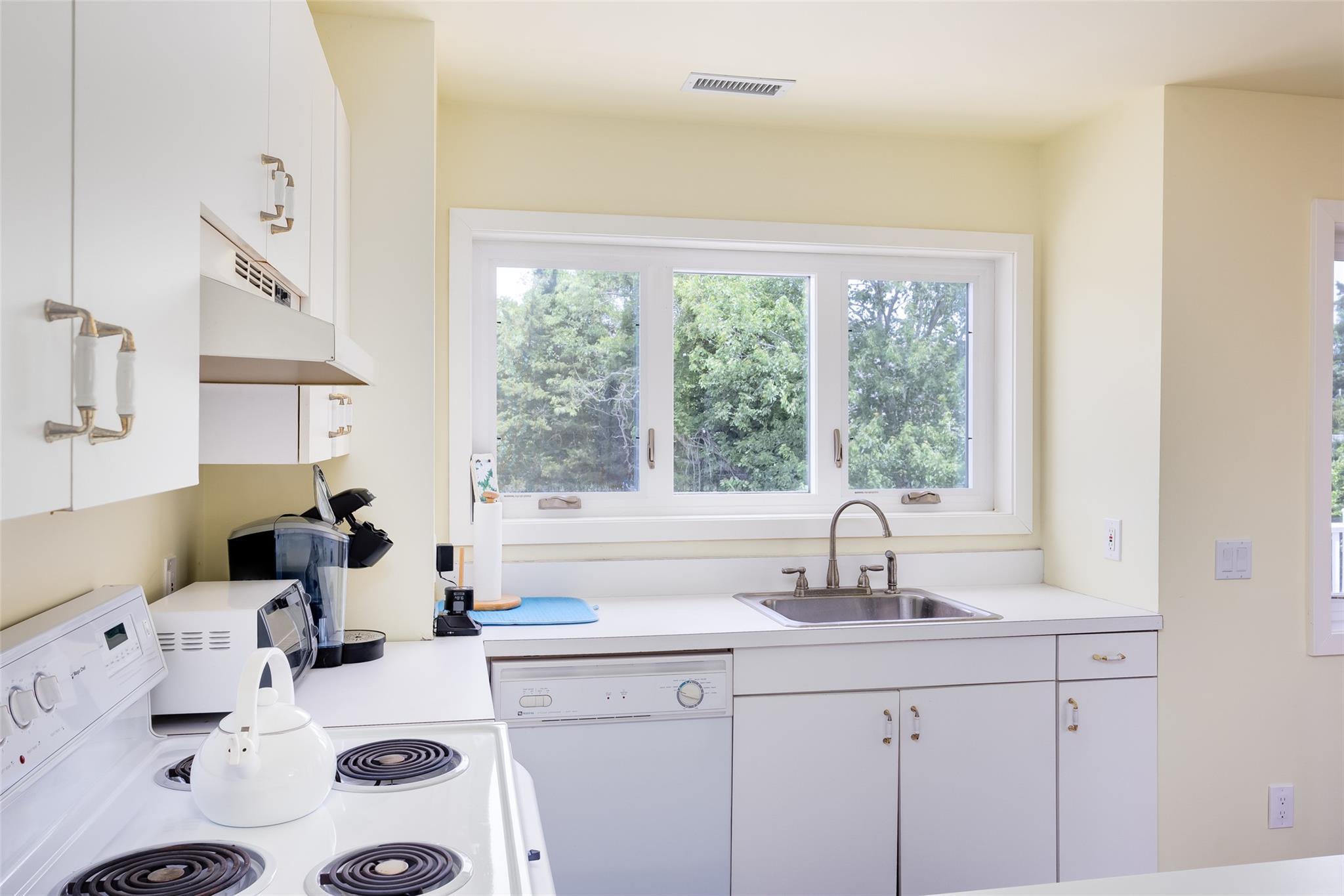 10 Bayview Road Remsenburg, NY 11960 - Photo 32 of 47 a kitchen with sink a large window cabinets and a couch