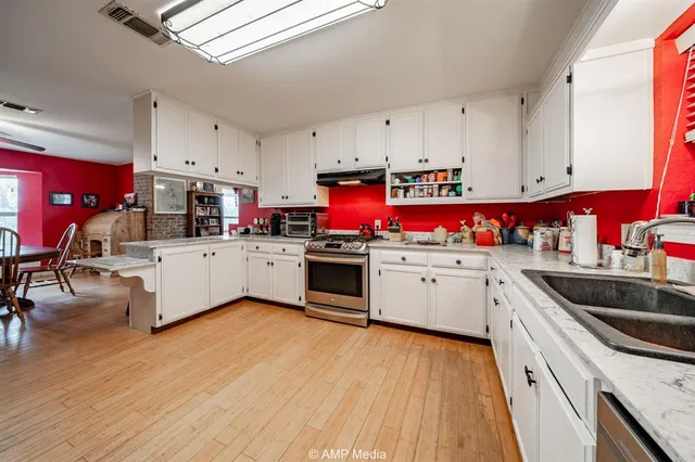 a kitchen with granite countertop white cabinets and stainless steel appliances
