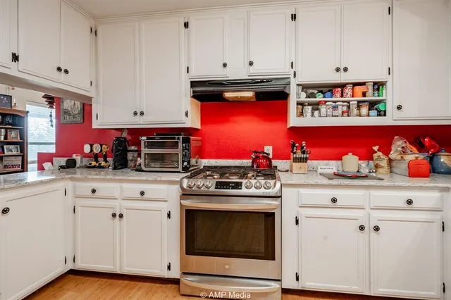 a kitchen with granite countertop white cabinets and sink