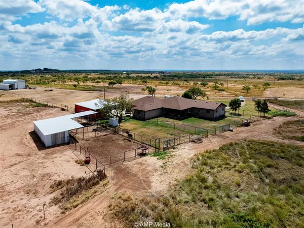 an aerial view of a pool with lawn chairs