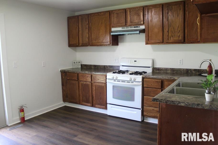 632 East 9th Street Kewanee, IL 61443 - Photo 11 of 36 a kitchen with granite countertop wooden cabinets and a stove top oven