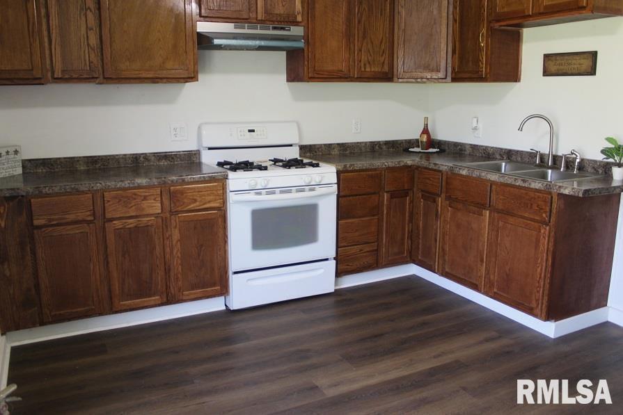 632 East 9th Street Kewanee, IL 61443 - Photo 6 of 36 a kitchen with granite countertop wood cabinets and a stove