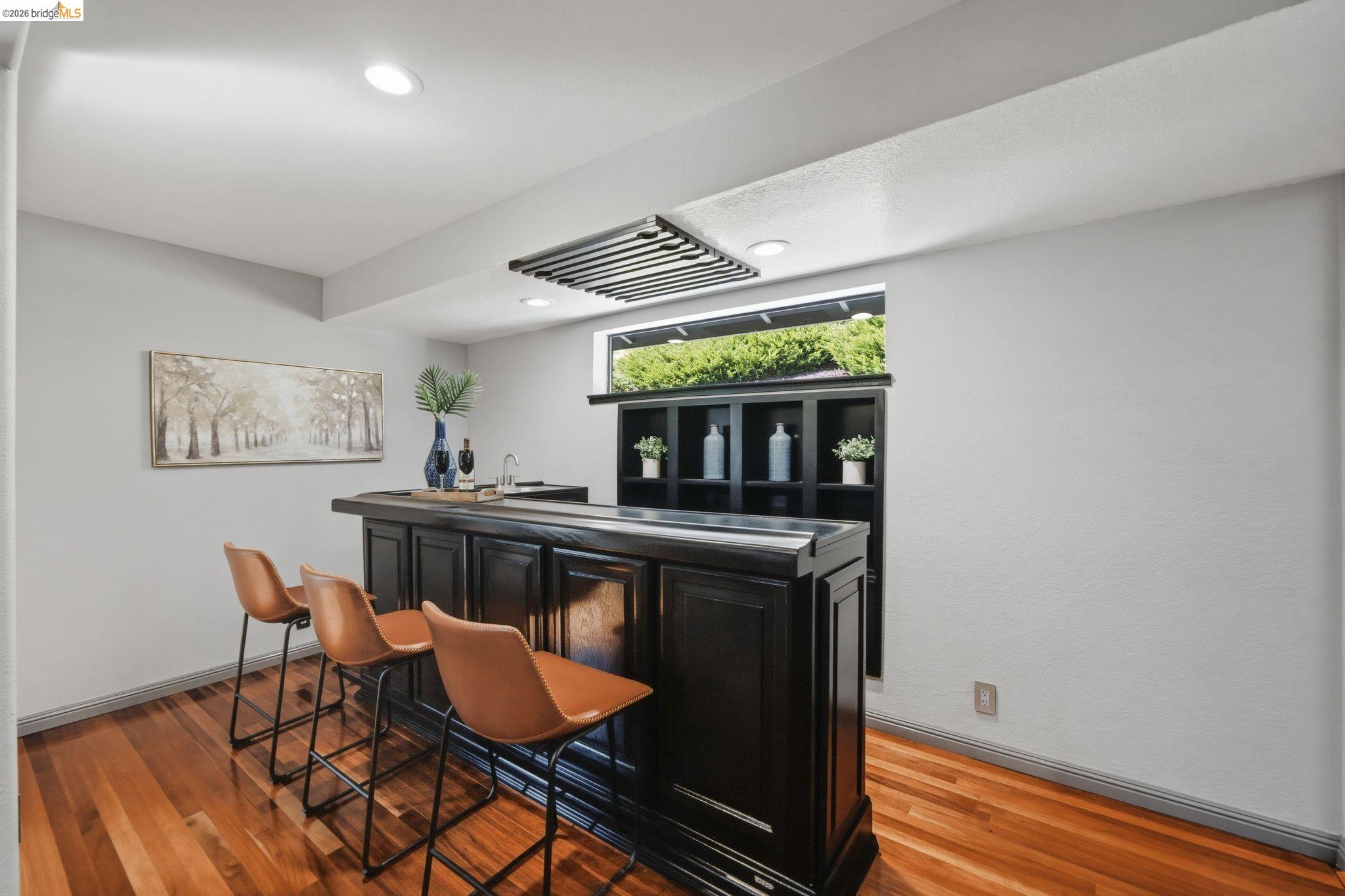 11133 Golf Links Road Oakland, CA 94605 - Photo 22 of 57 Built-in wet bar featuring dark wood-finish cabinetry, a recessed sink, and an integrated storage hutch