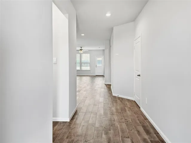 a view of a hallway with wooden floor